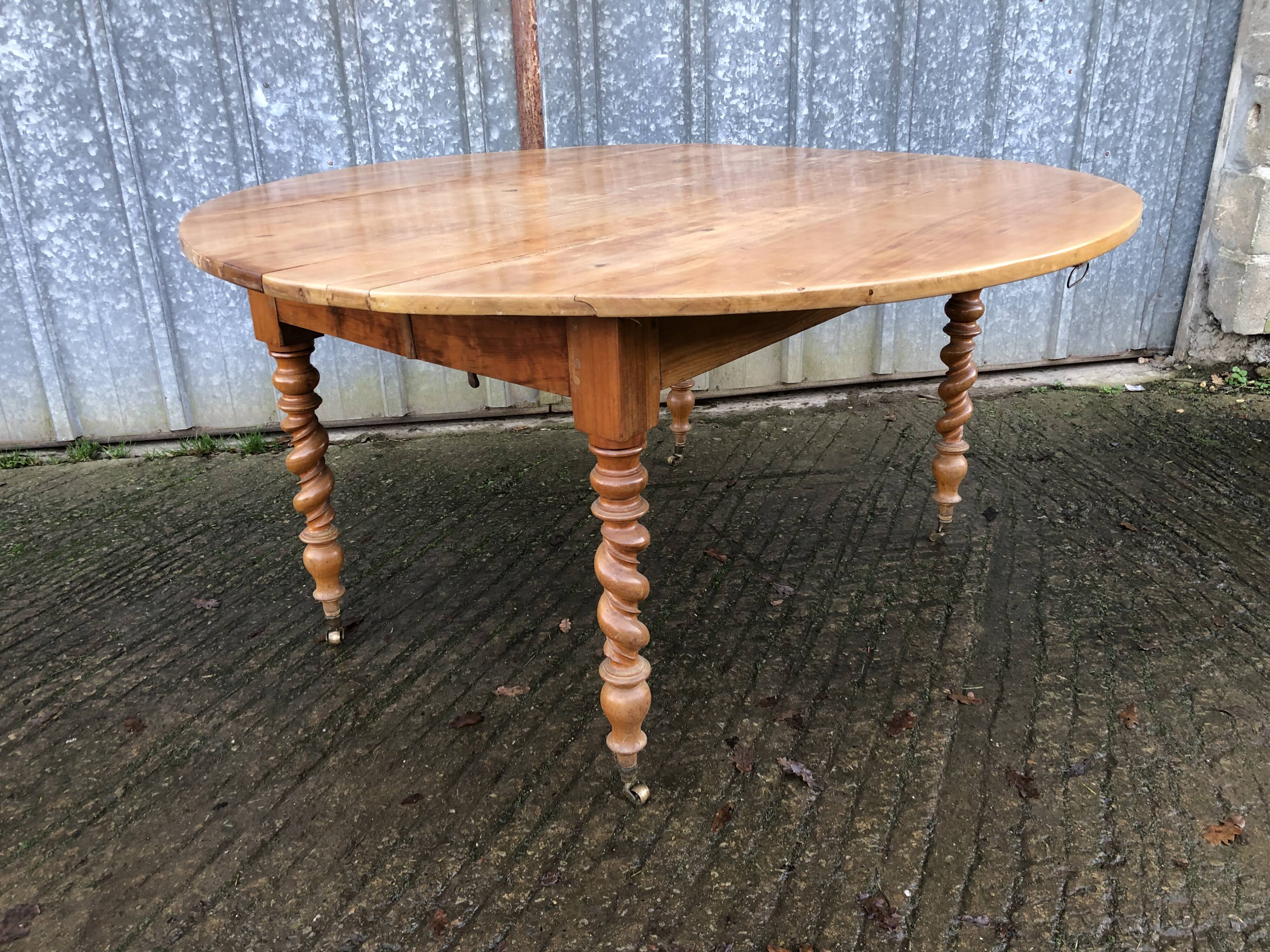 Round table in solid cherry wood, extendable with twisted legs, Louis Philippe style.