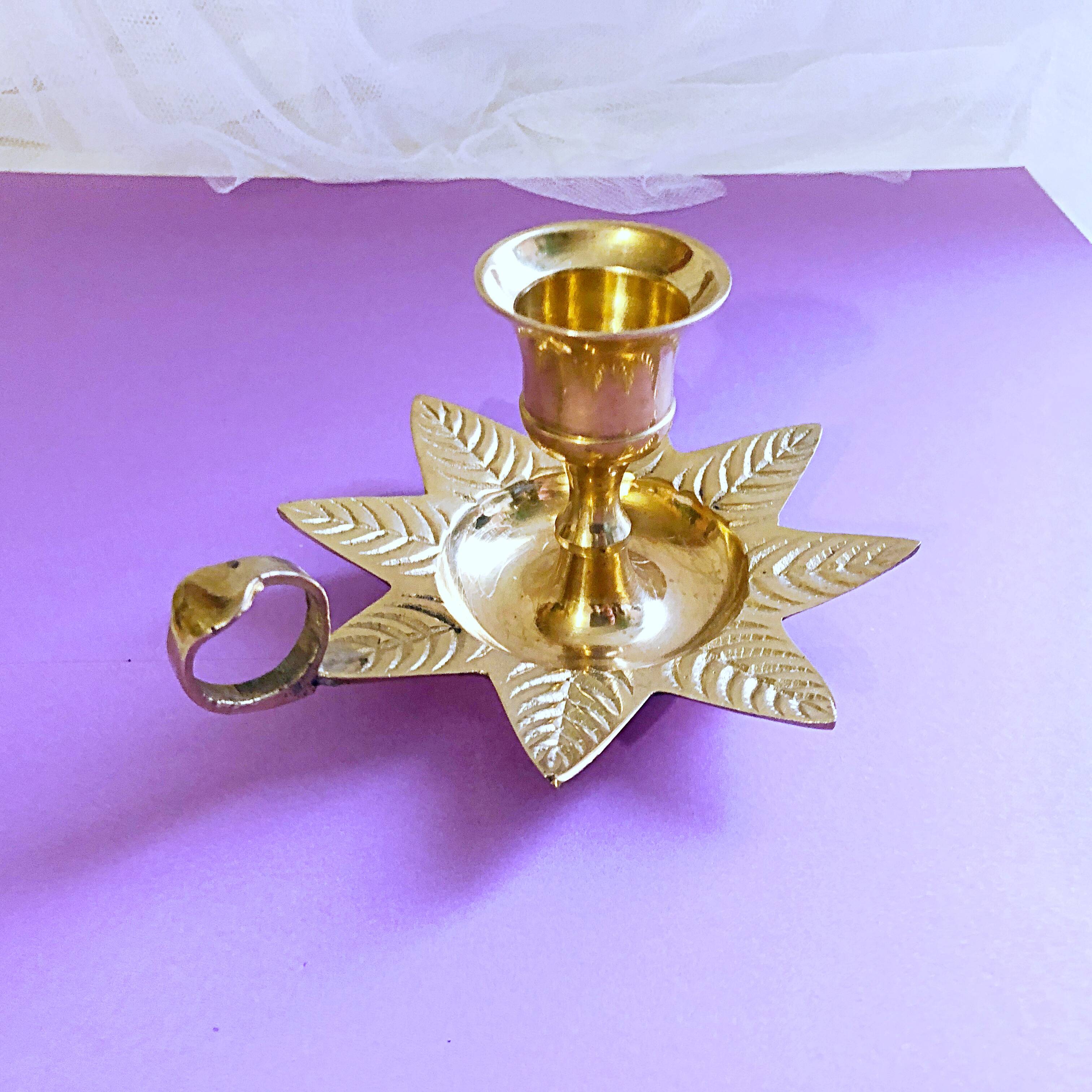 Golden brass hand candle holder decorated with leaves