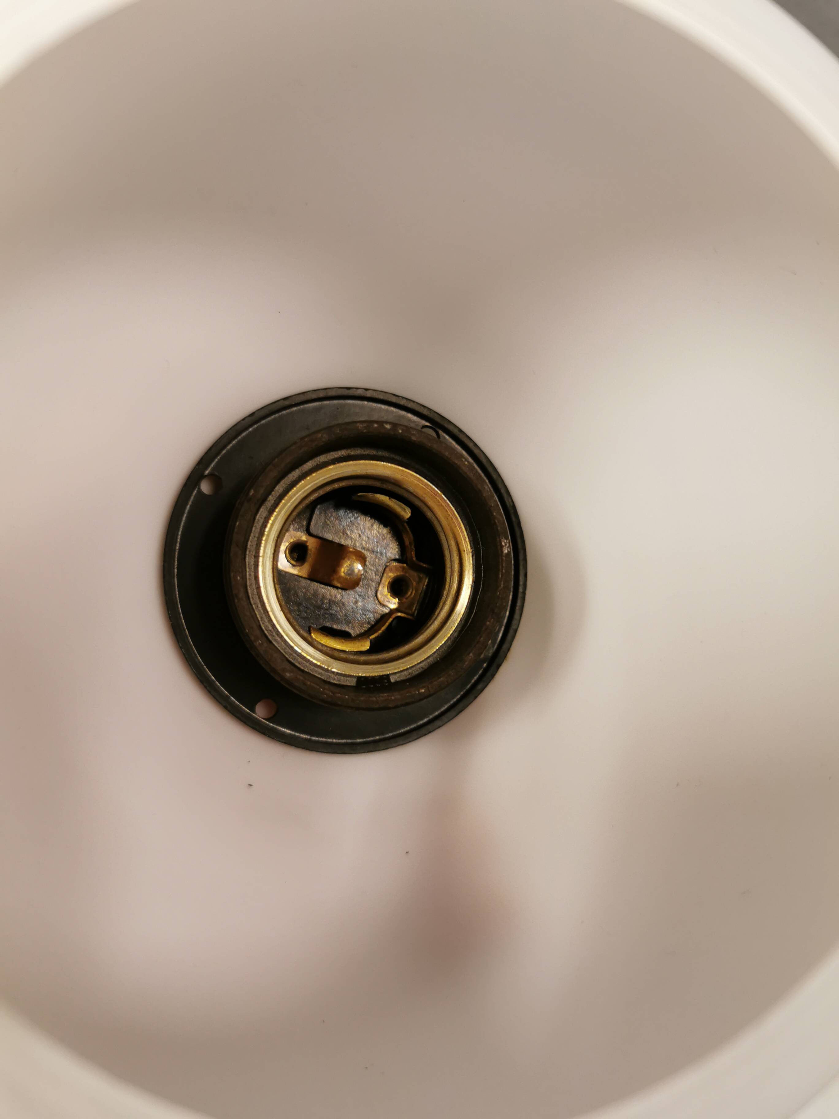 Milky white Holmegaard wall lamp with glass shade and a brass detail on top. Wooden wall bracket