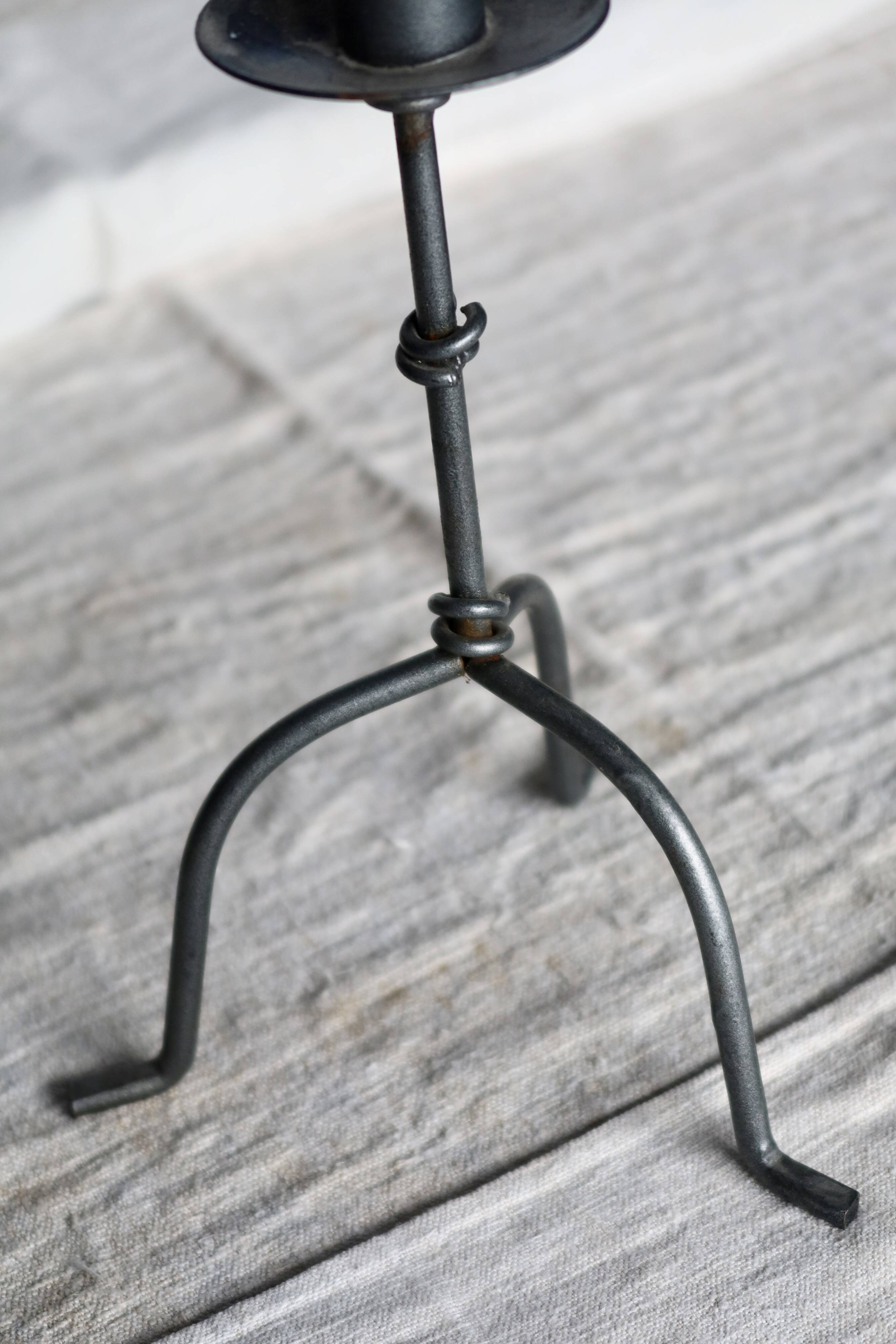Antique tripod metal candlestick with knot decoration