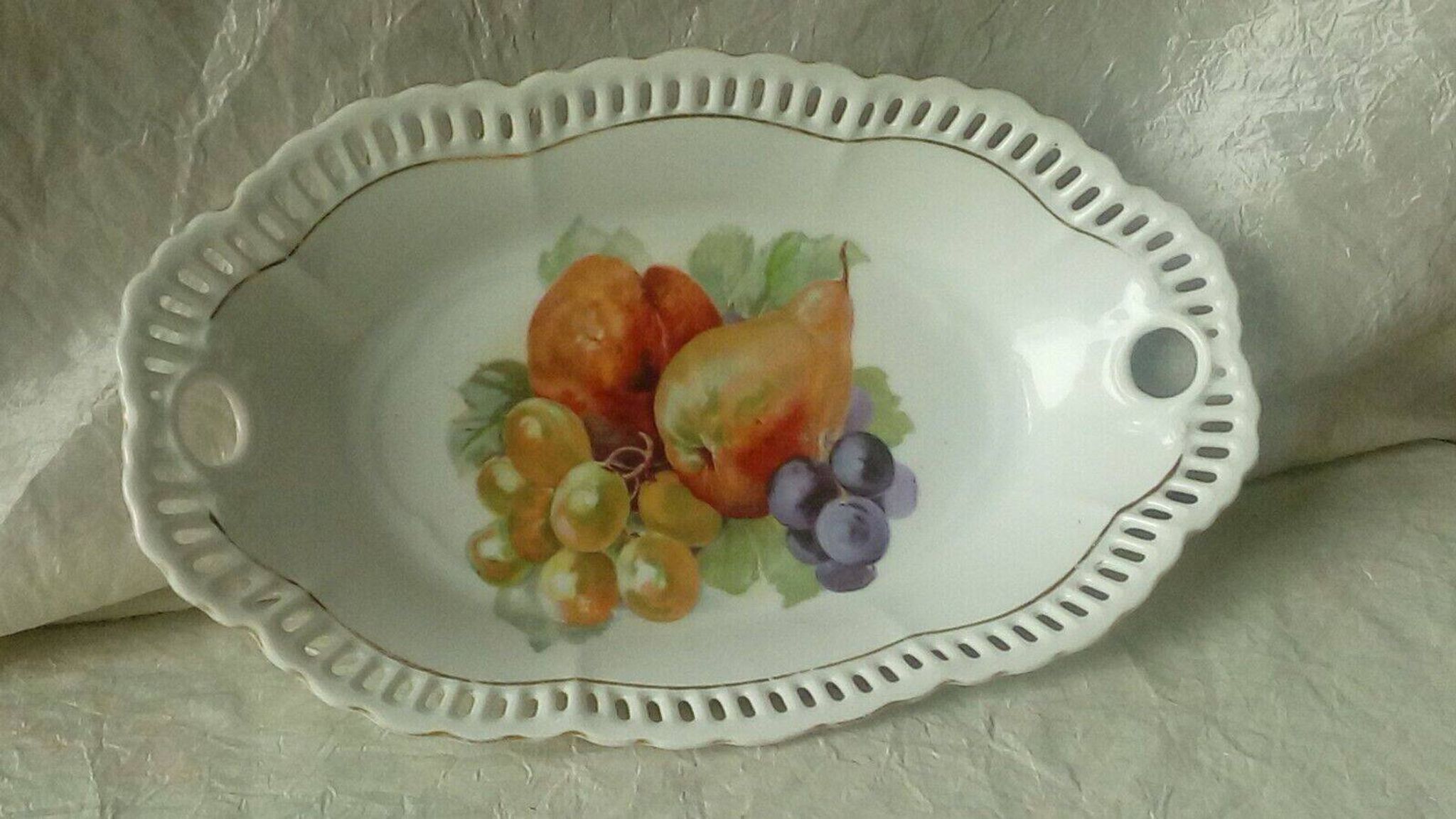 Pierced porcelain basket decorated with fruit still life.