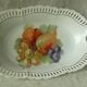 Pierced porcelain basket decorated with fruit still life.