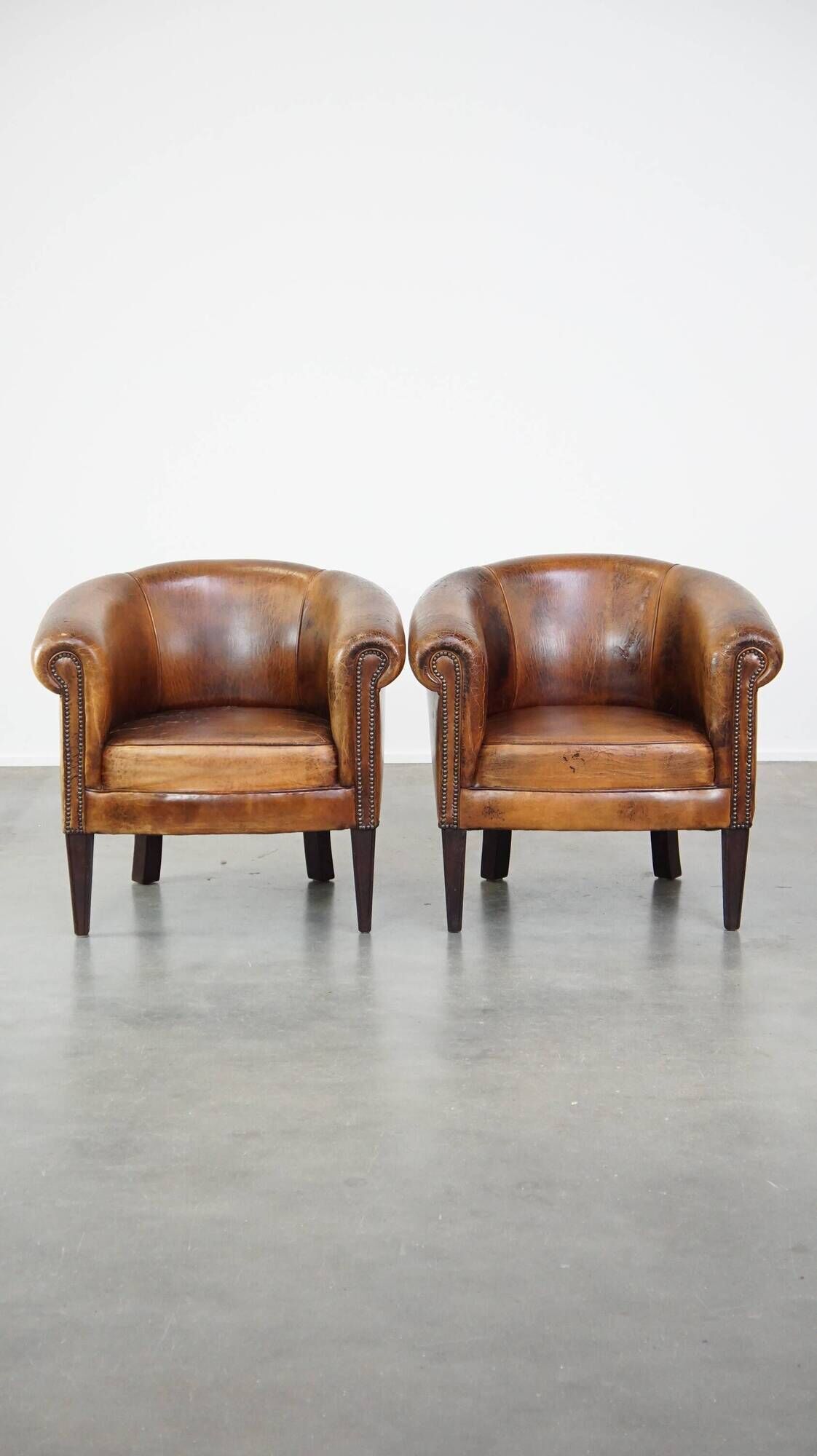 Set of 2 subtle, stately and sturdy club chairs made of sheepskin