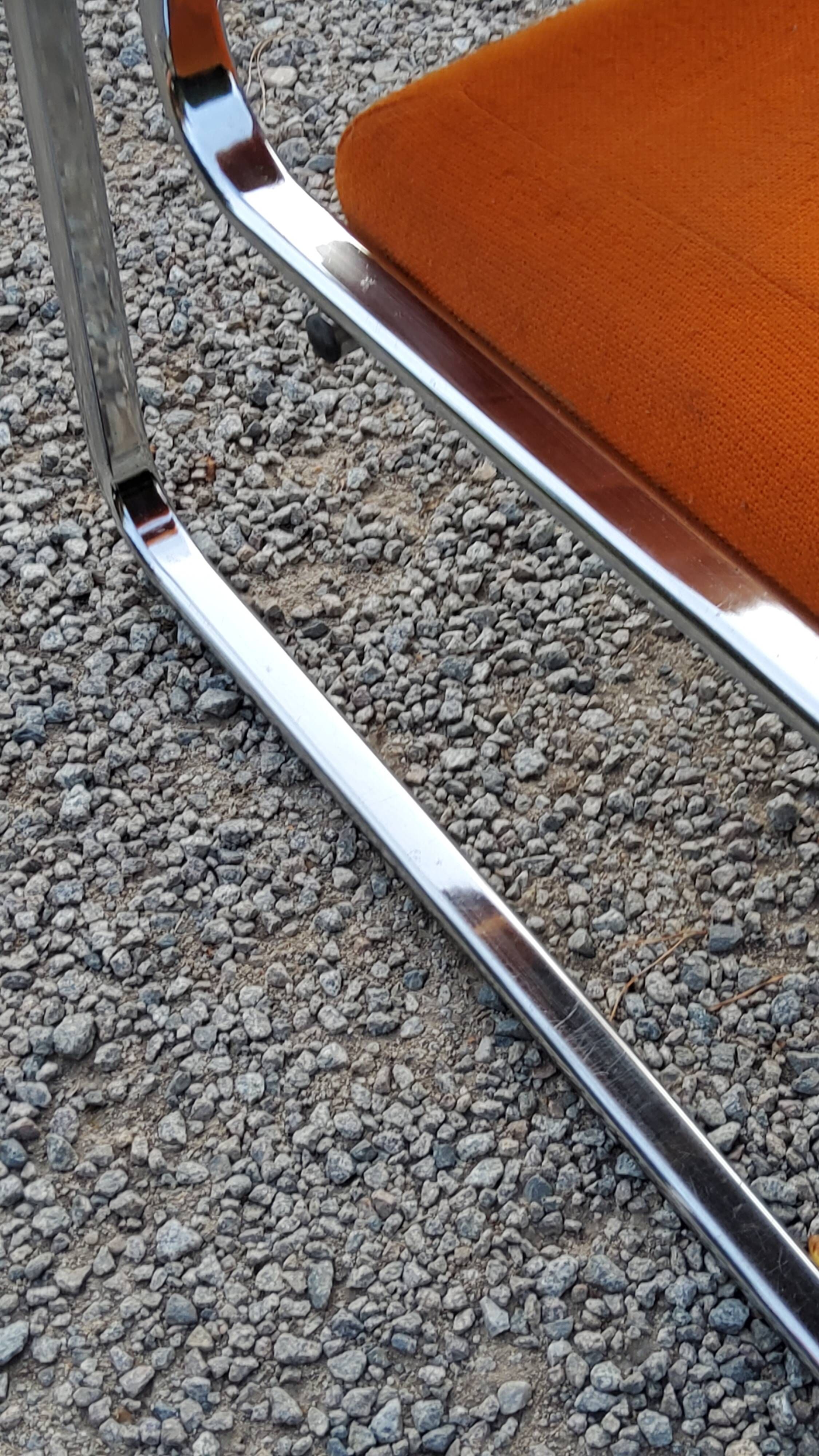Pair of designer armchairs in orange fabrics and chrome tubes from the 70s