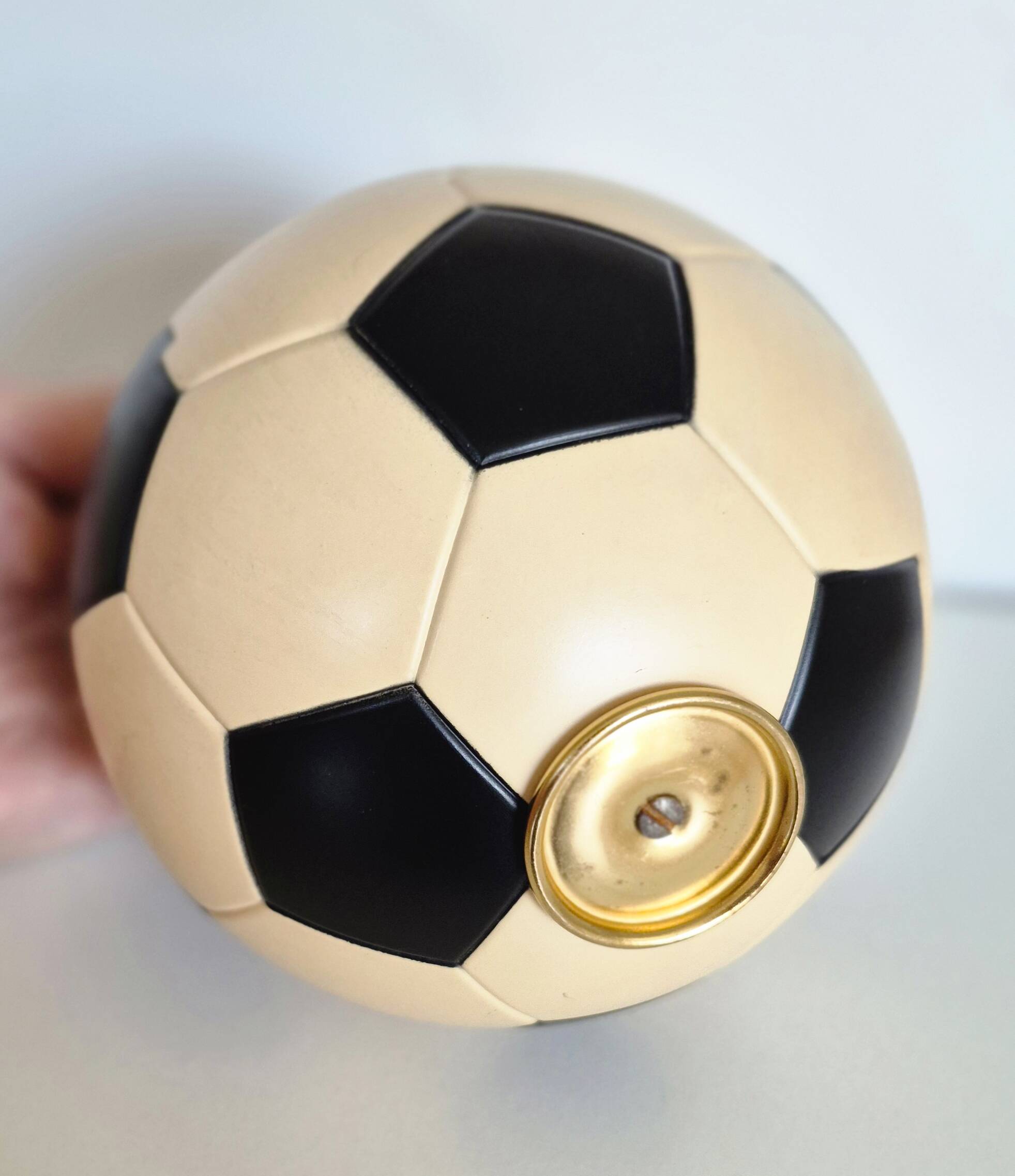 Vintage cigarette dispenser in the shape of a football.