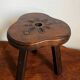 Tabouret tripode en bois sculpté