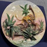 Plat en céramique figurant un lion attaquant une girafe