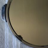 A large round mirror tray with metal handles