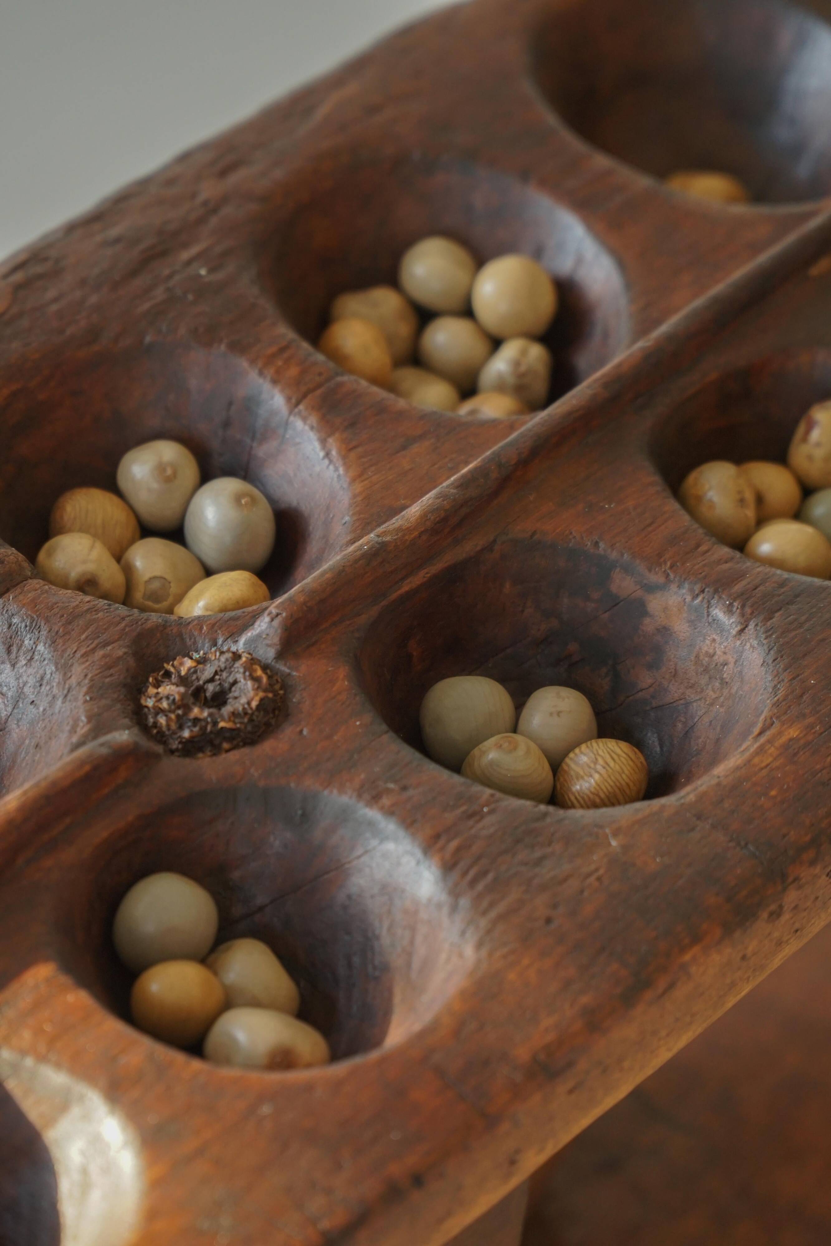 Decorative Mancala game board made of hand-carved wood, Africa, mid-20th century.