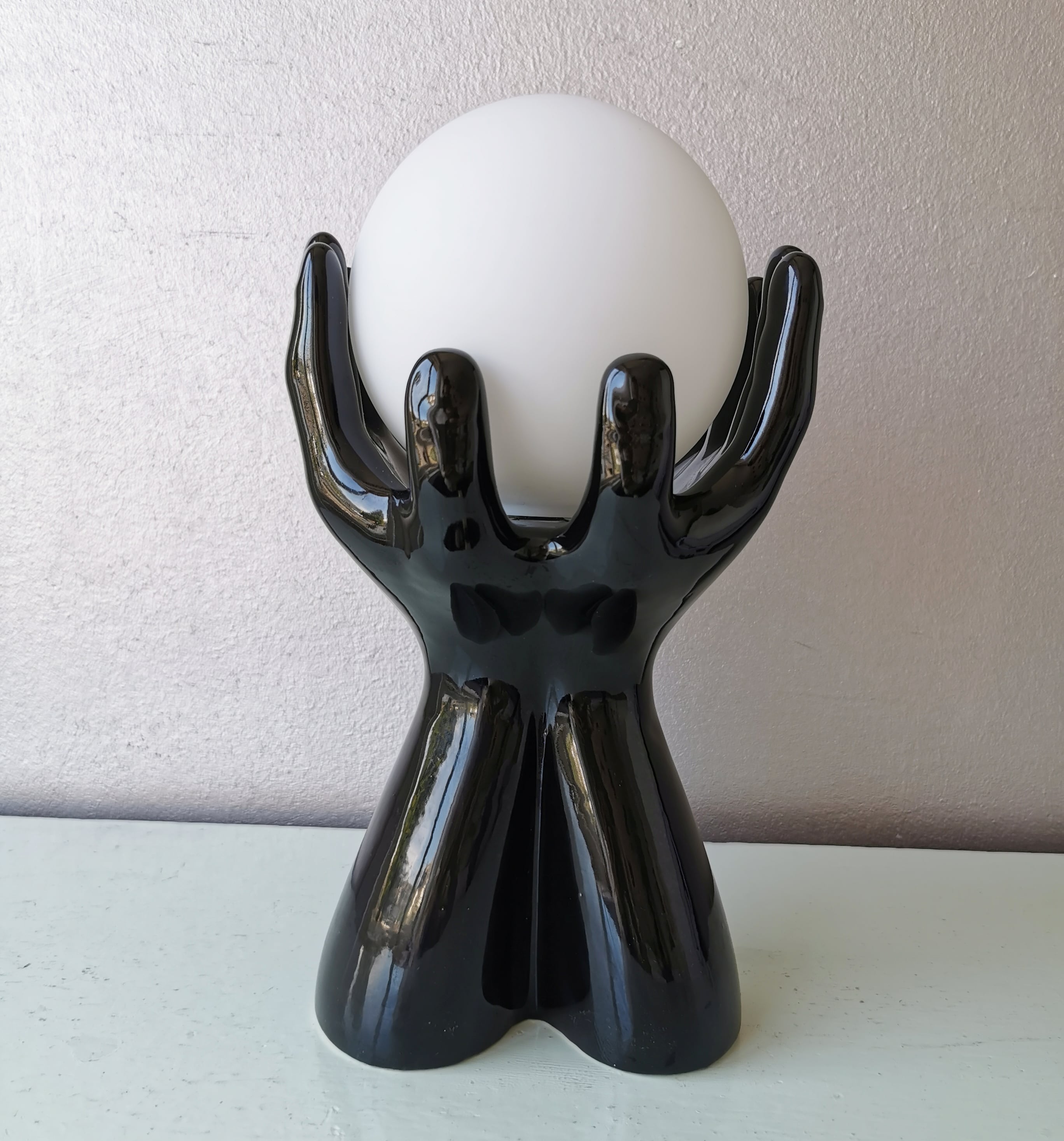 Italian design ceramic table lamp, two hands and glass shade.