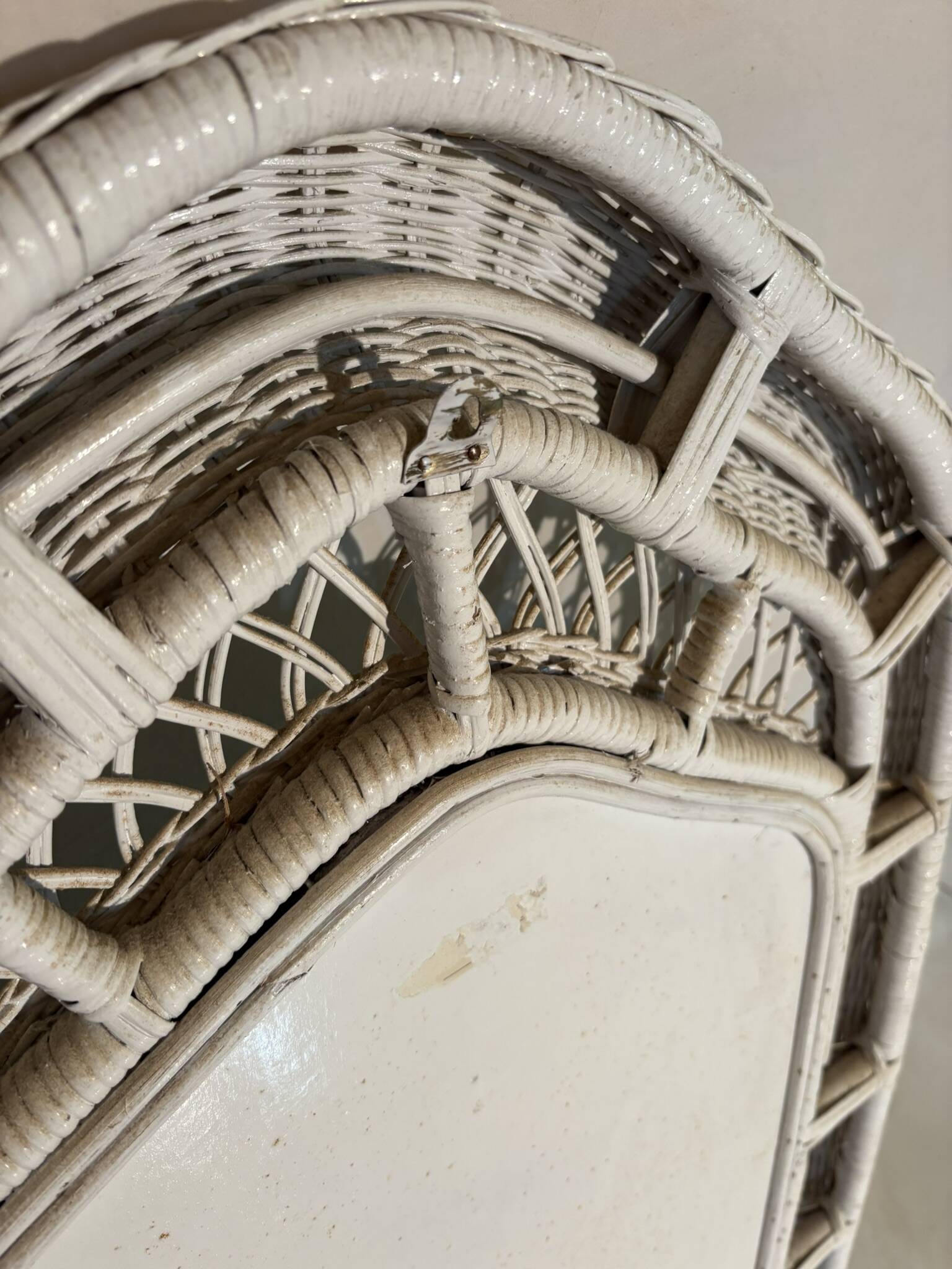 Vintage white rattan mirror with a gothic frame.