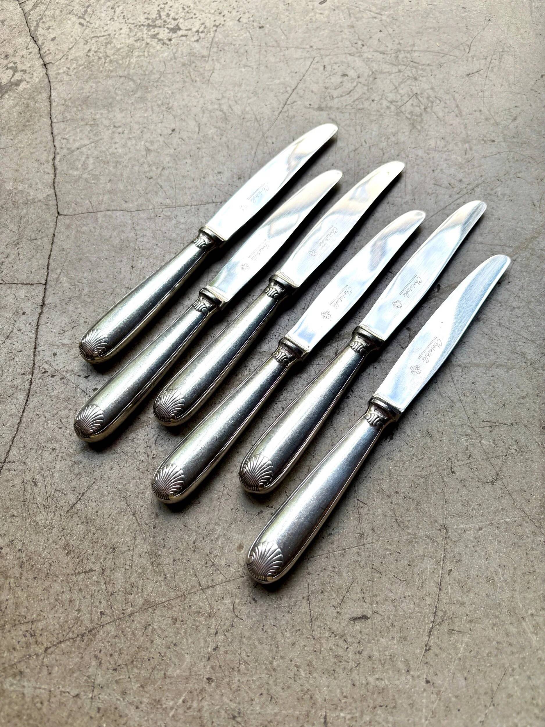 6 dessert knives by Christofle in silver-plated metal, shell decoration.