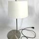 Large brushed metal table lamp with an ecru shade.