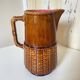 Antique vintage ceramic pitcher or jug from Sarreguemines, France. Brown with a pink interior, imitation basket.