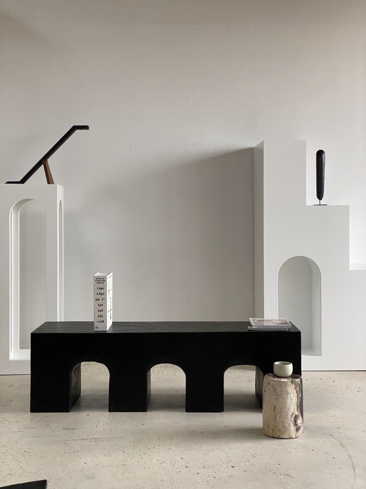 Black solid monoxyl wood bench carved into 3 arches