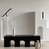 Black solid monoxyl wood bench carved into 3 arches