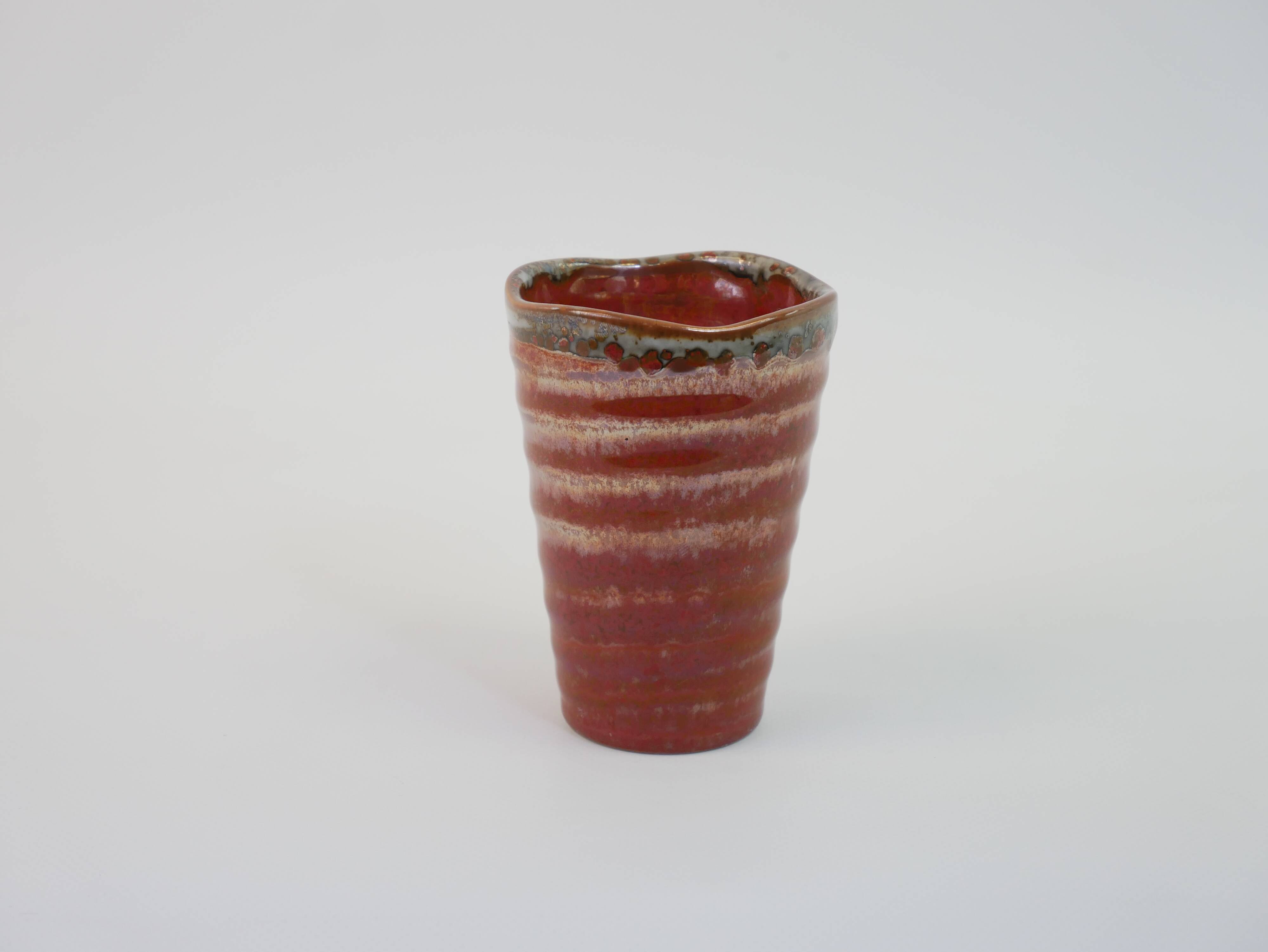 Small orange glazed ceramic cup