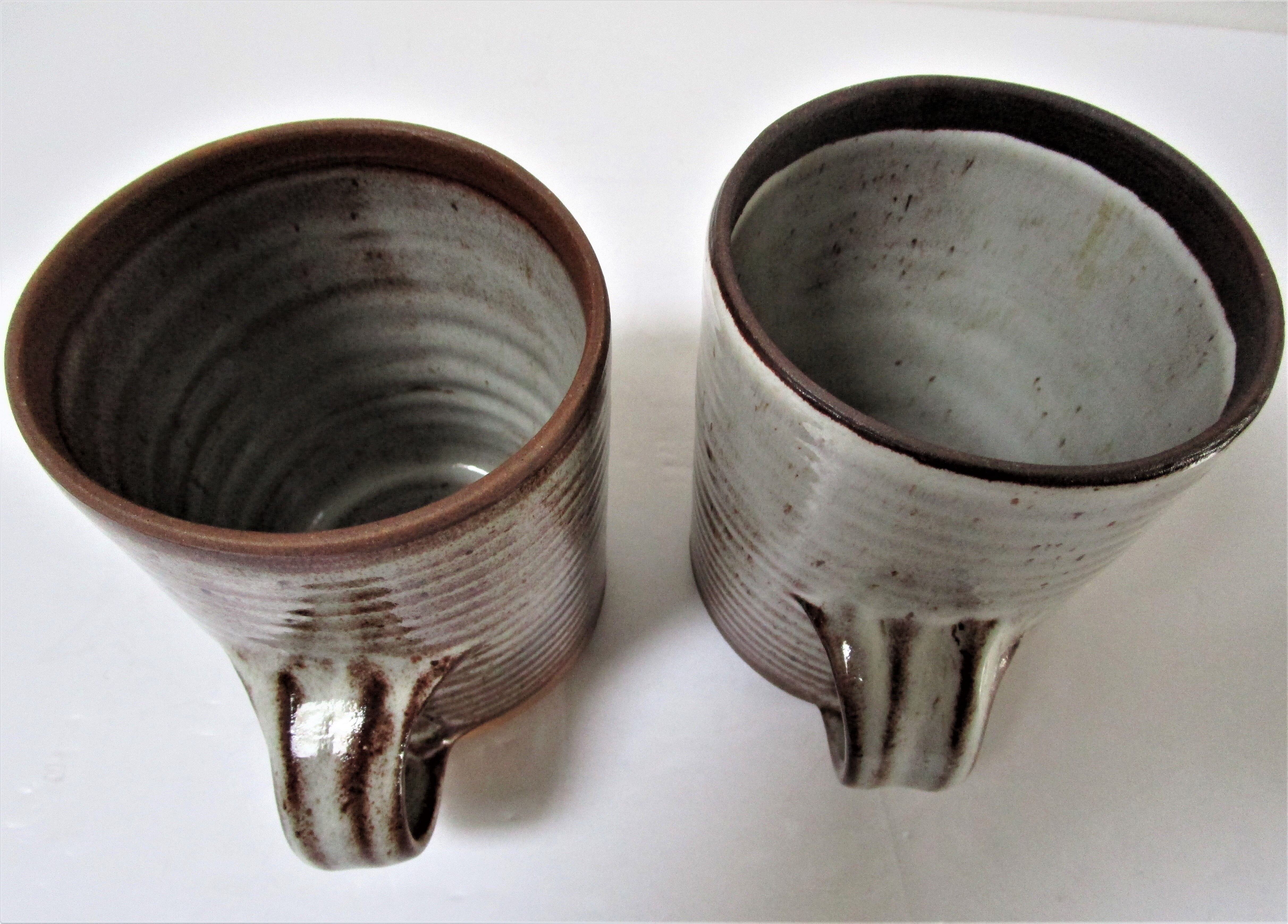 Two enamelled sandstone mugs Roger Jacques handwritten signature