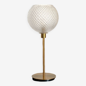 Table lamp with a large old globe and a golden foot