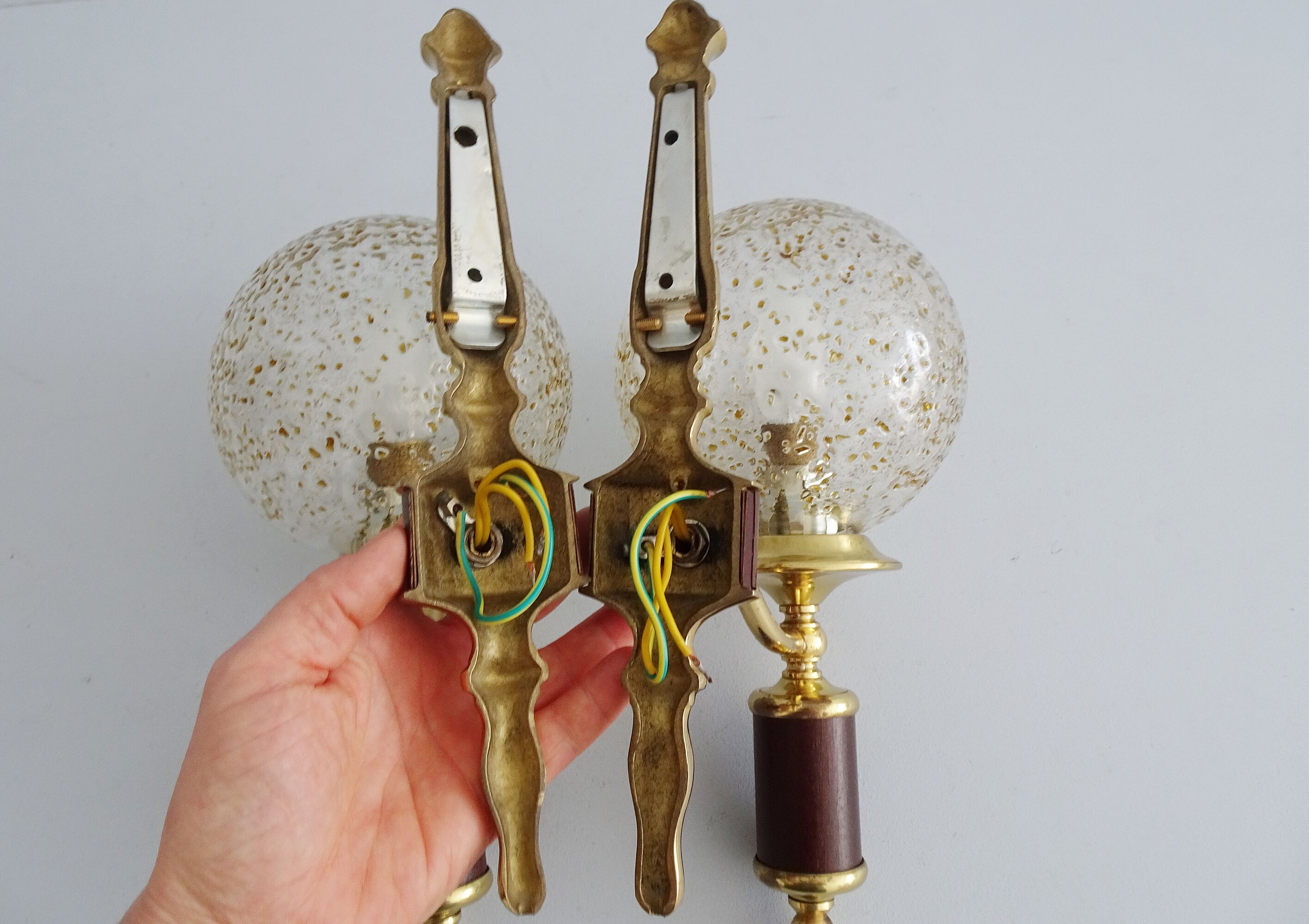 Golden wall lamps with round glass shades and teak veneer