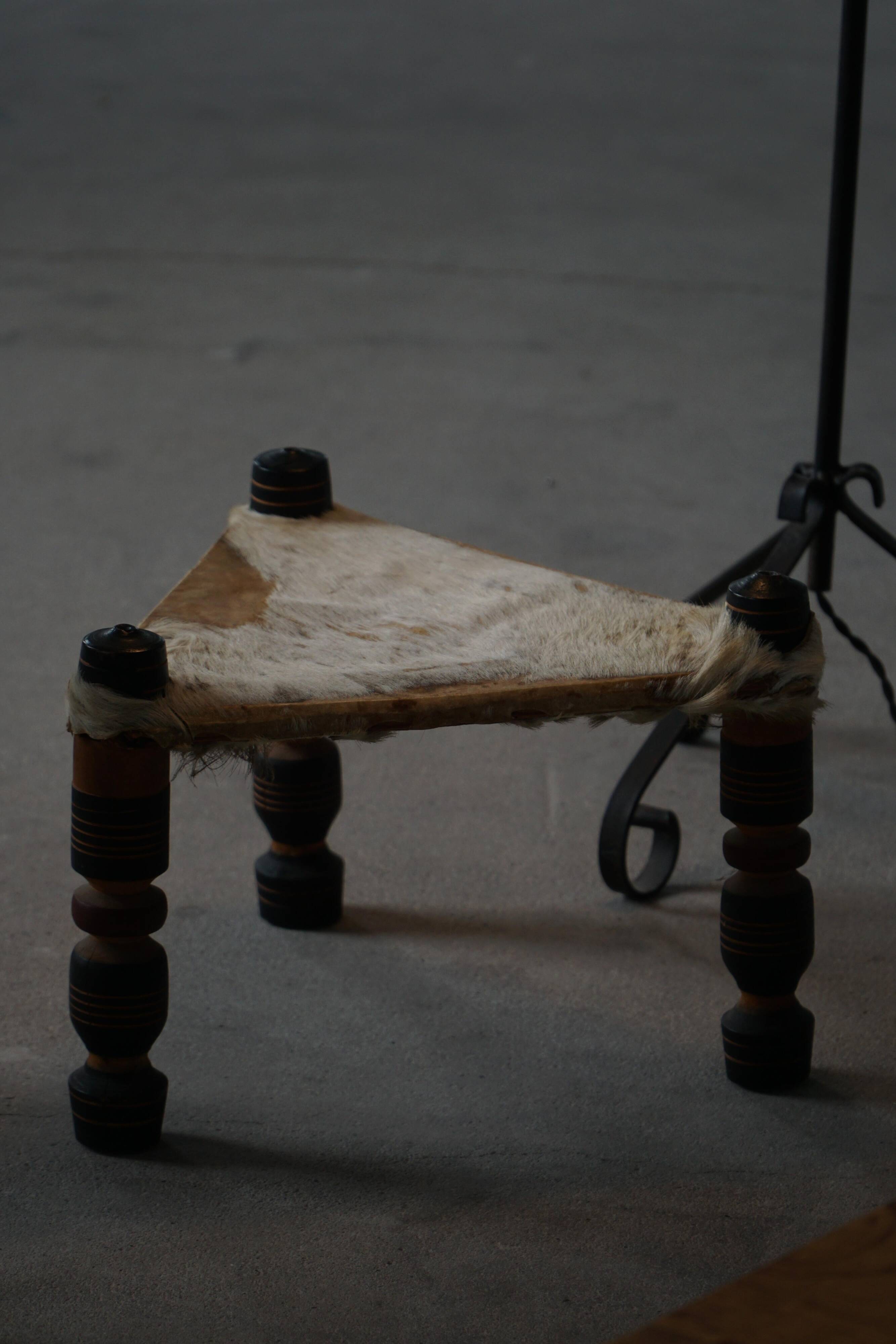 Vintage African artisanal stool, triangular shape with 3 legs, cowhide, 20th century.