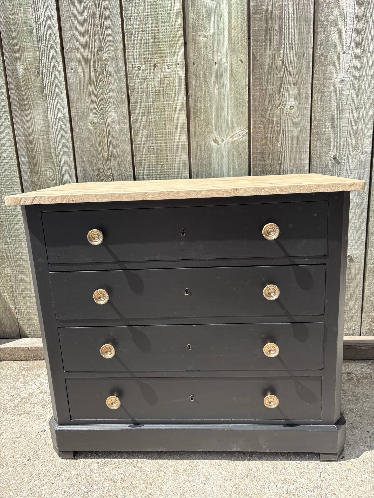 Antique commode with a matte black finish.