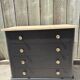 Antique commode with a matte black finish.