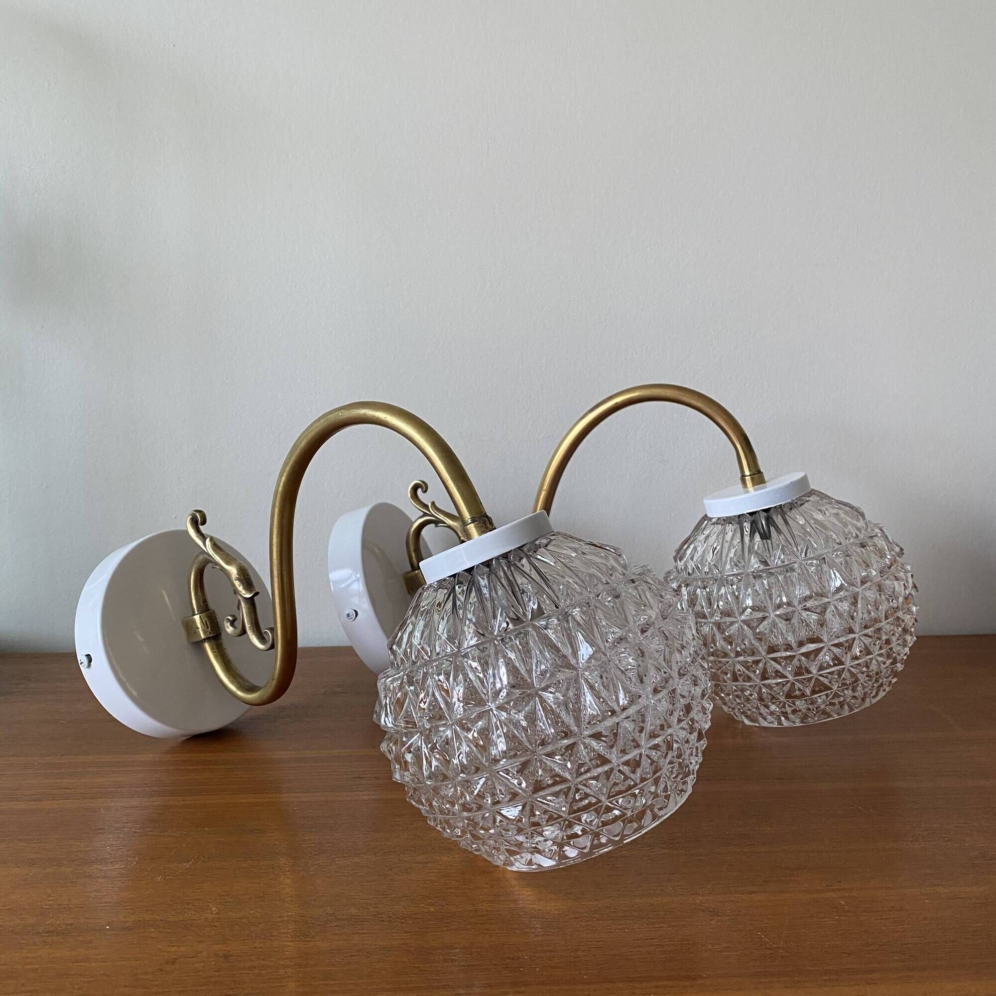Large pair of brass swan neck wall lights with transparent glass globes.