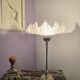 Table lamp with a silver base and a frilled shade.