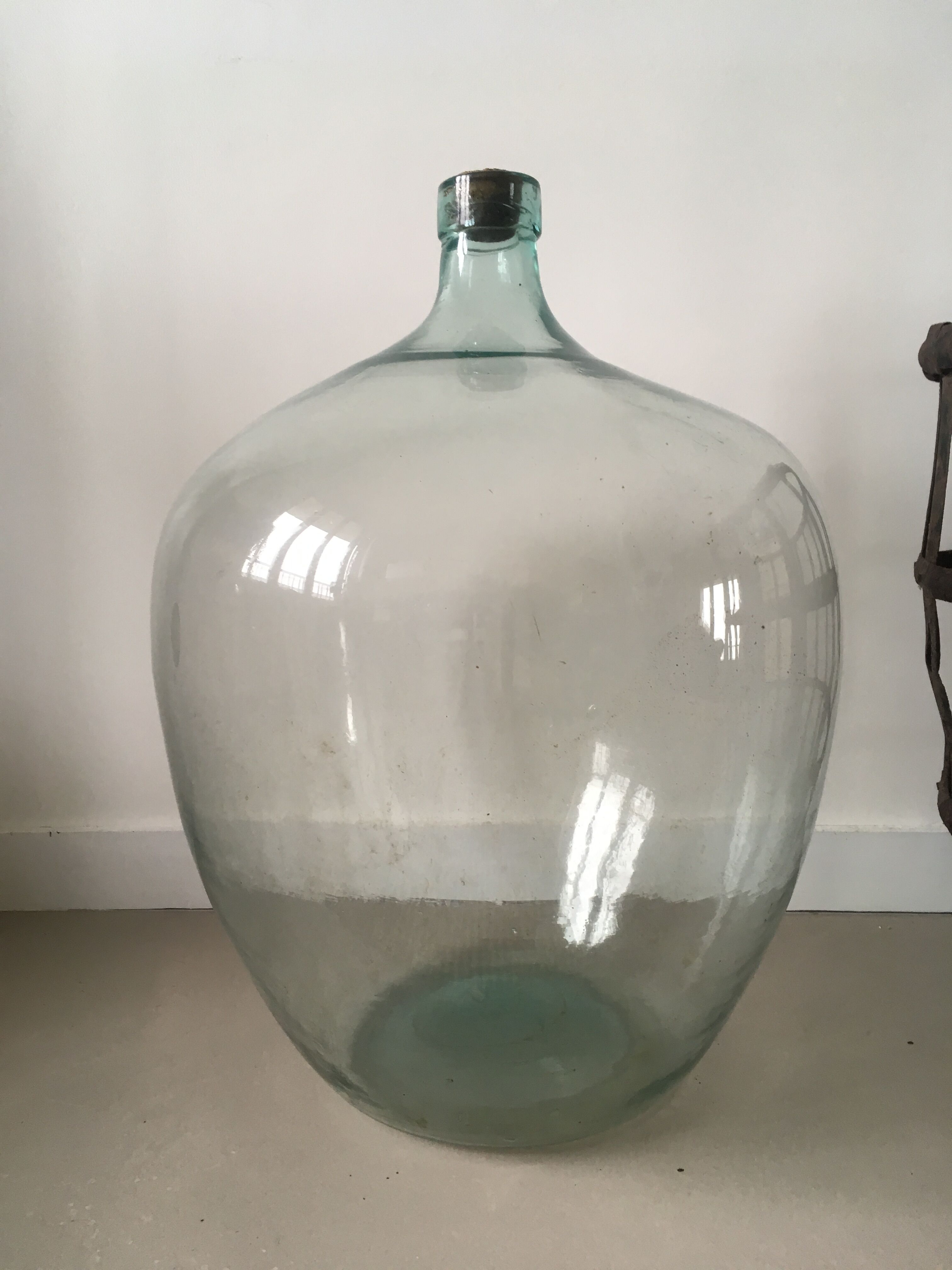 Old demijohn and her metal basket