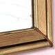 Art Deco mirror in gilded wood with curved floral decorations.