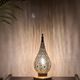 Handmade brass table lamp with a perforated drop-shaped shade.