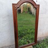 Old beveled solid wood mirror of a cabinet door.