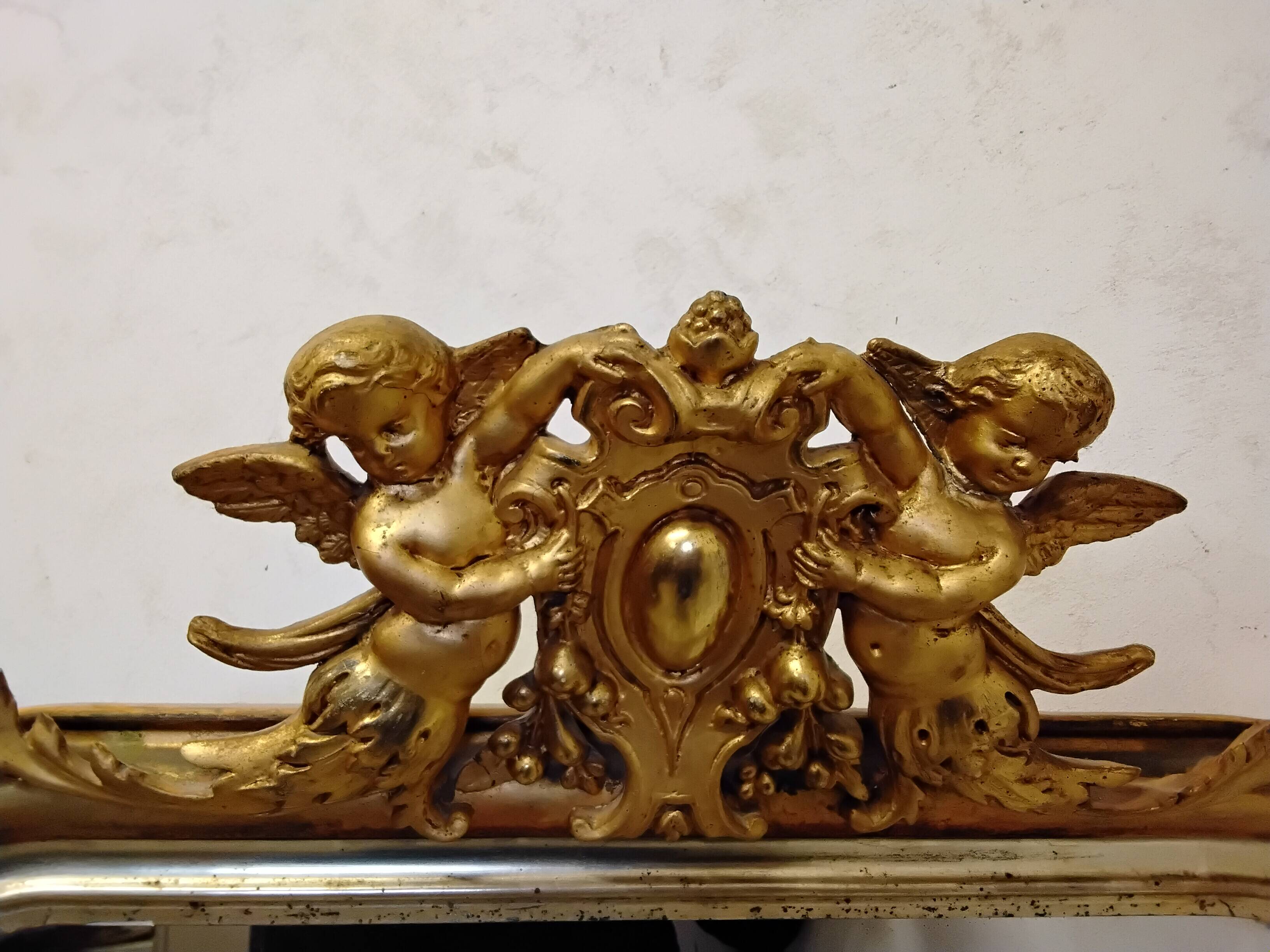 Antique mirror with a gilded frame and cherubs.