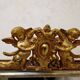 Antique mirror with a gilded frame and cherubs.