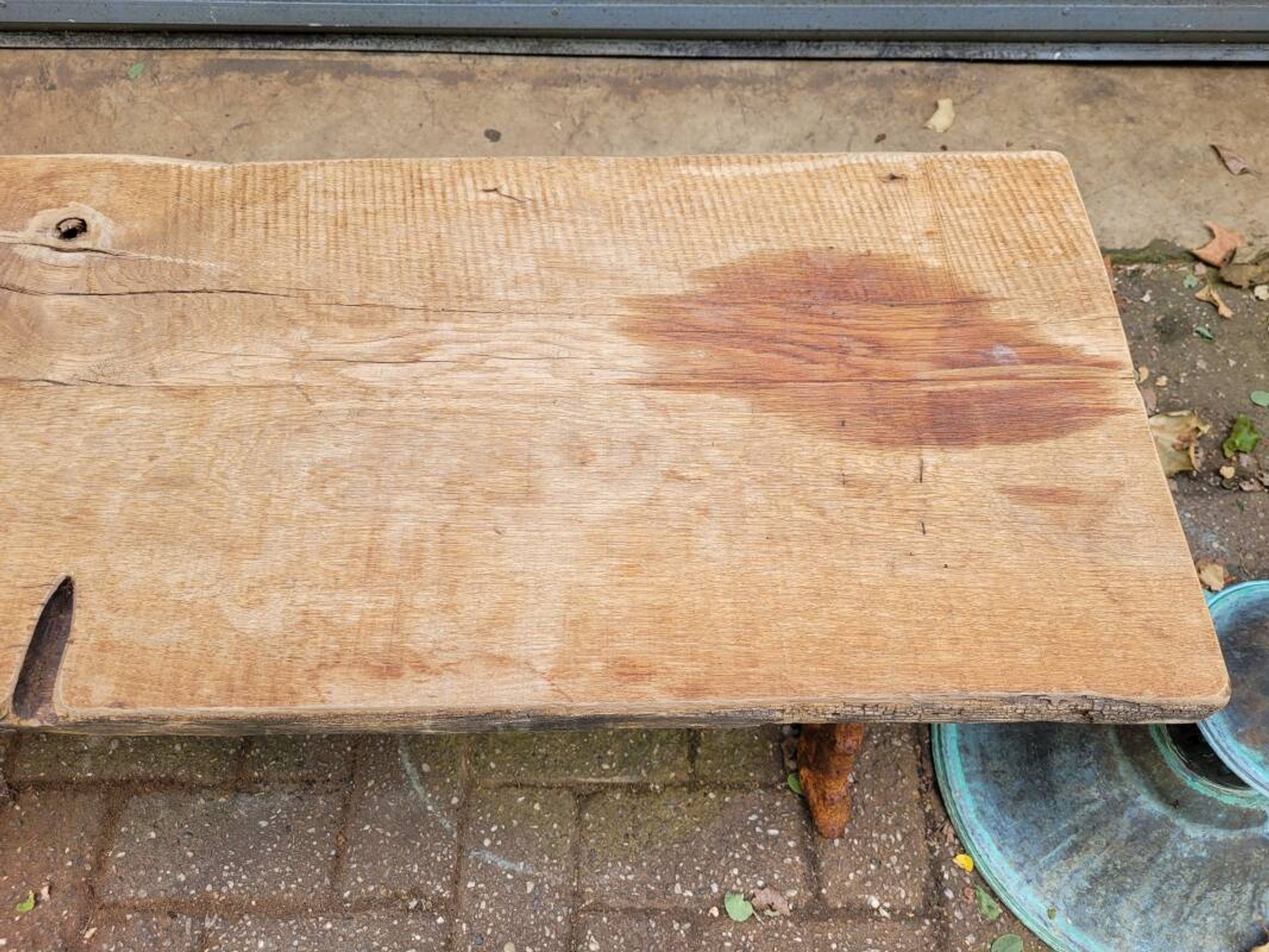 French country-style cast iron garden bench with old barn wood plank.