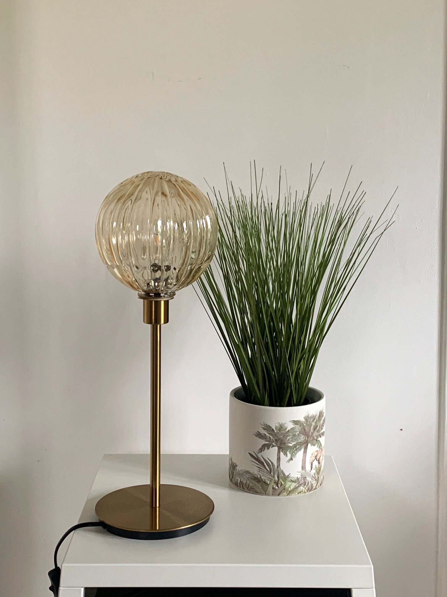 Table lamp with an antique golden streaked globe and a golden foot