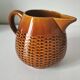 Caramel slipware pitcher with braided relief