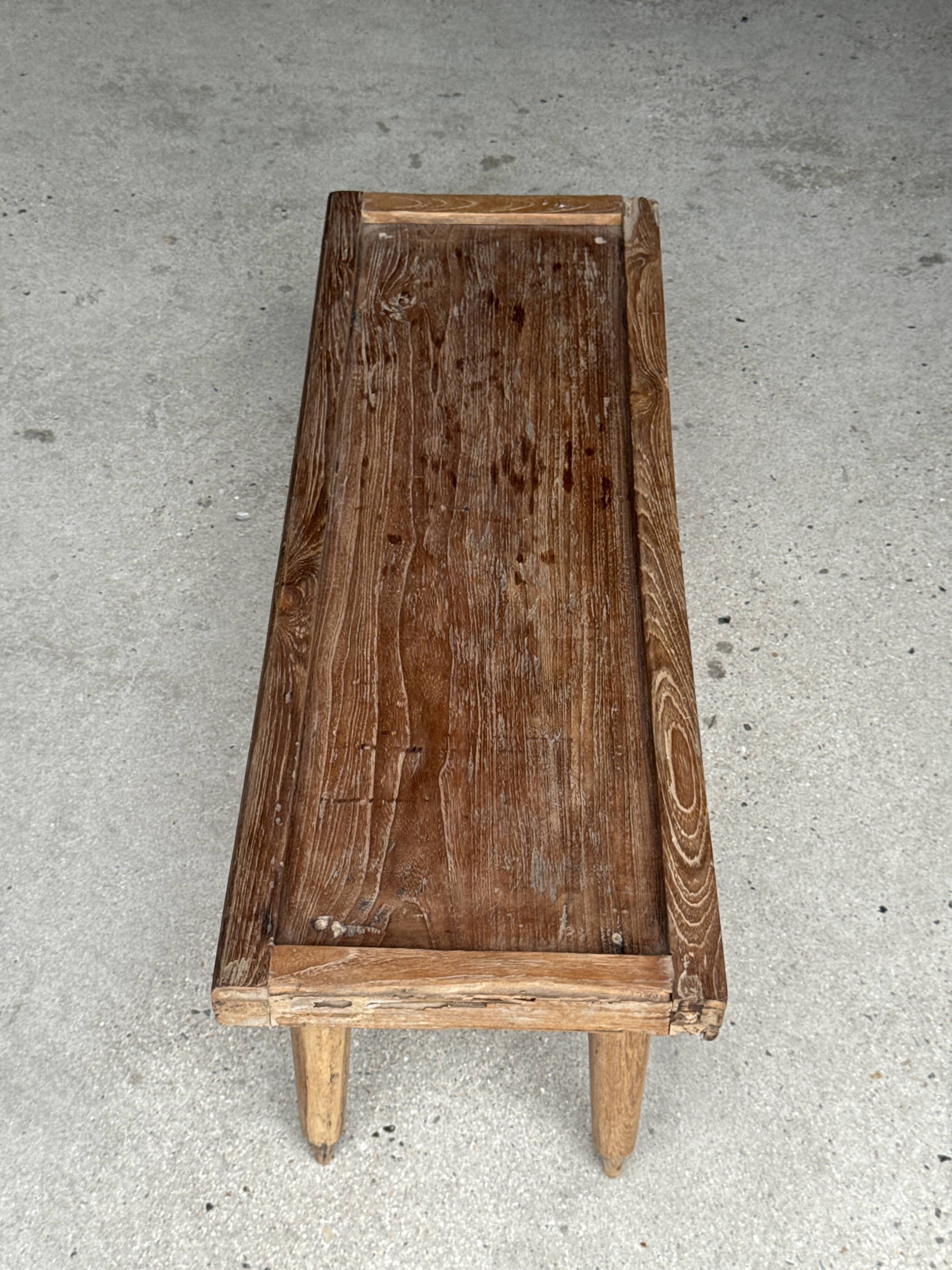 Brown Indonesian teak coffee table, with a border and cylindrical legs H40 L103.