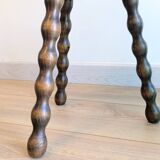 Small wooden tripod stool with turned legs, country style.