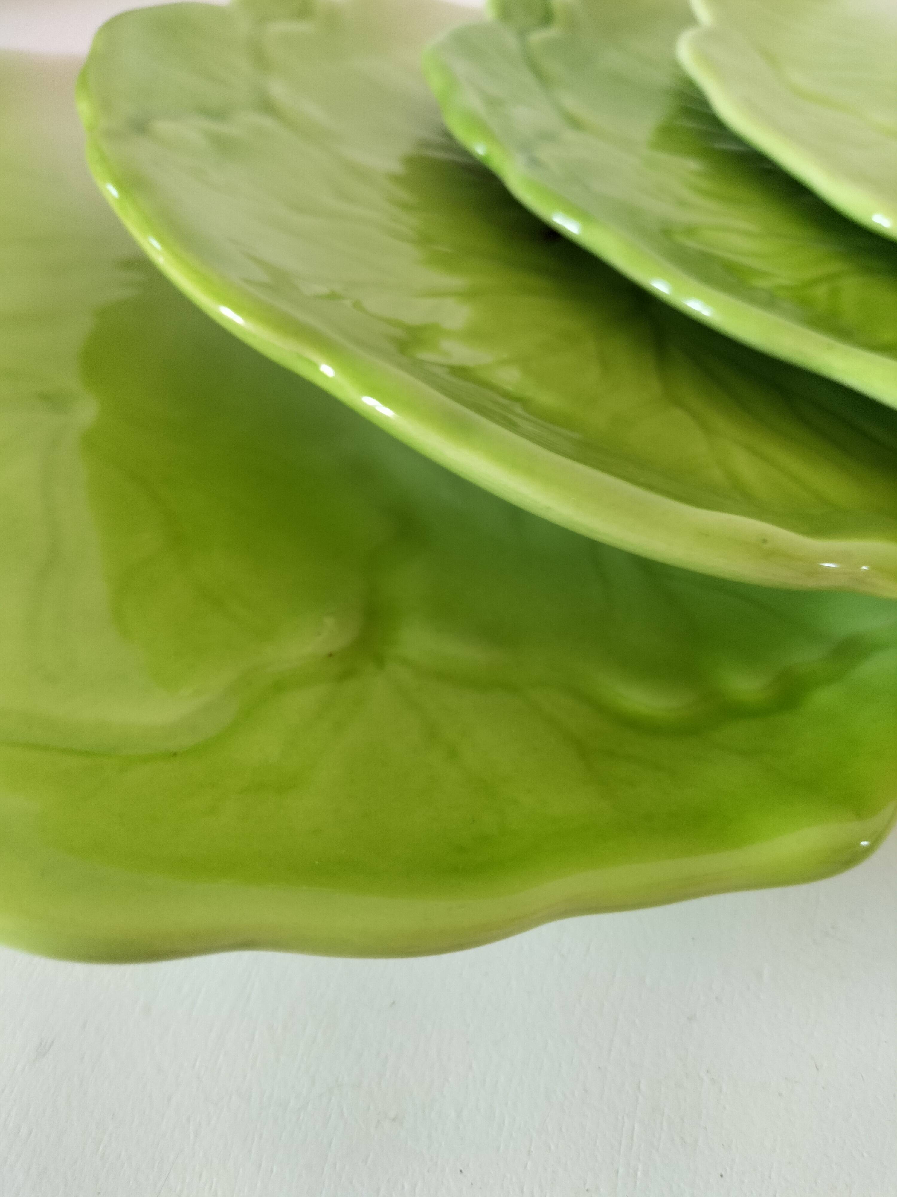 4 hand-decorated earthenware plates with vegetable and green leaf designs.