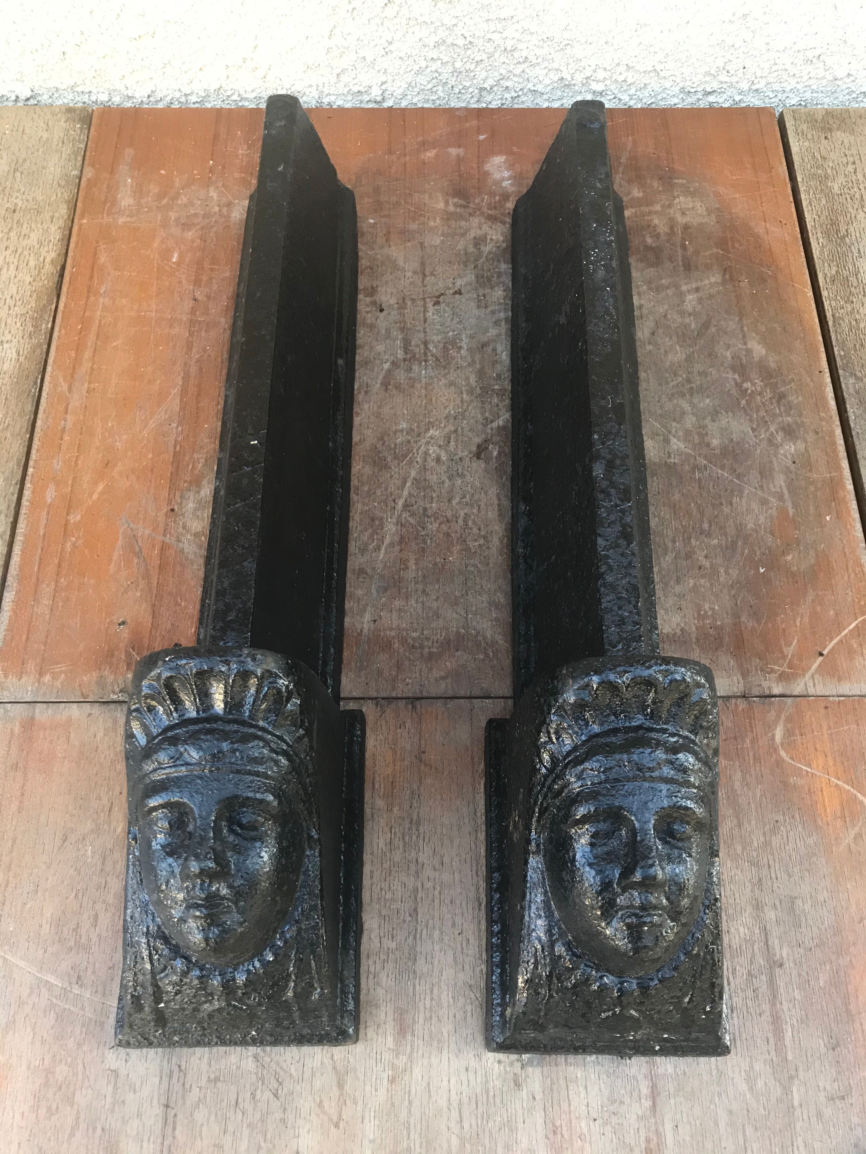 Old pair of chimney caterpillars shape of the head of a woman in iron
