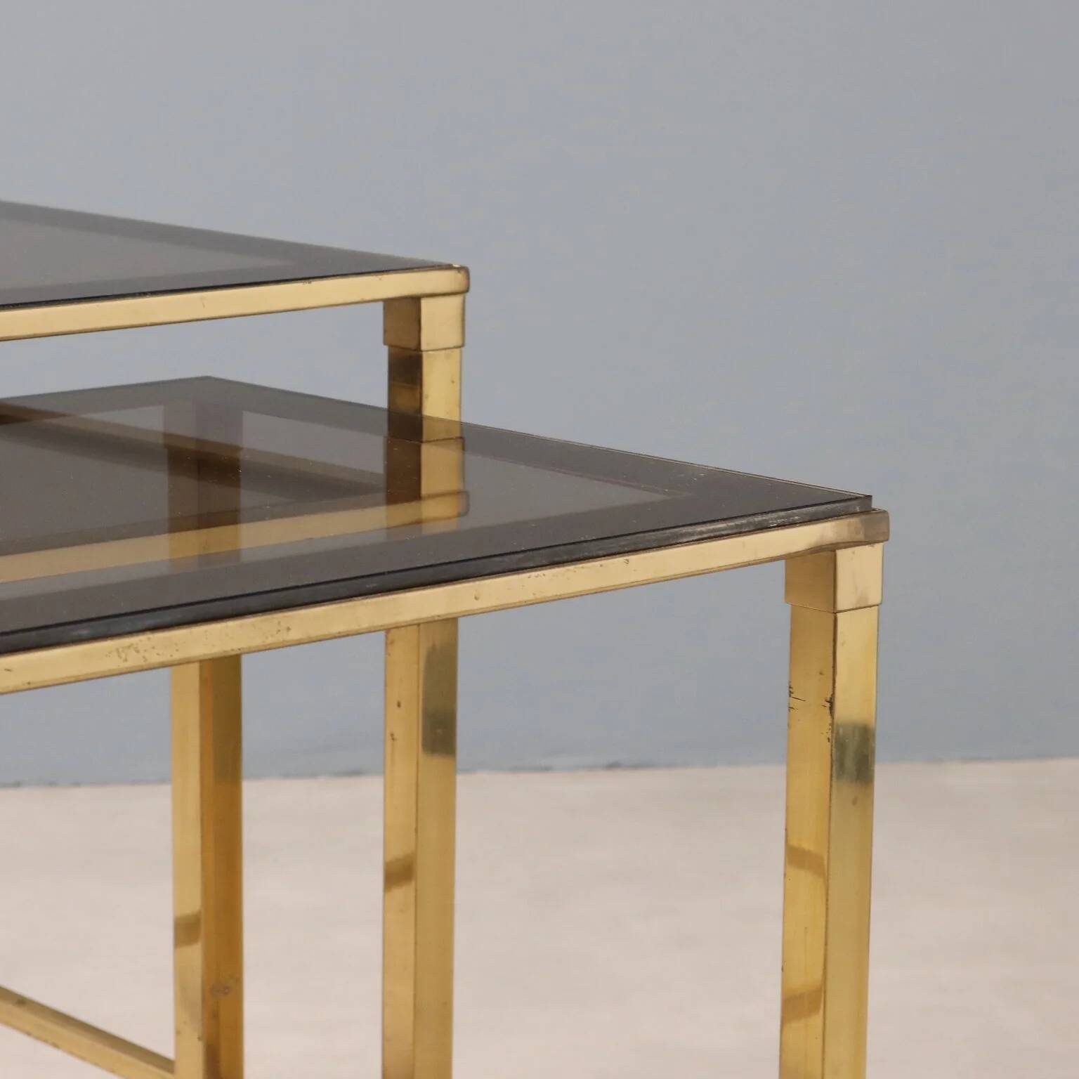 Nested tables in brass and smoked glass.