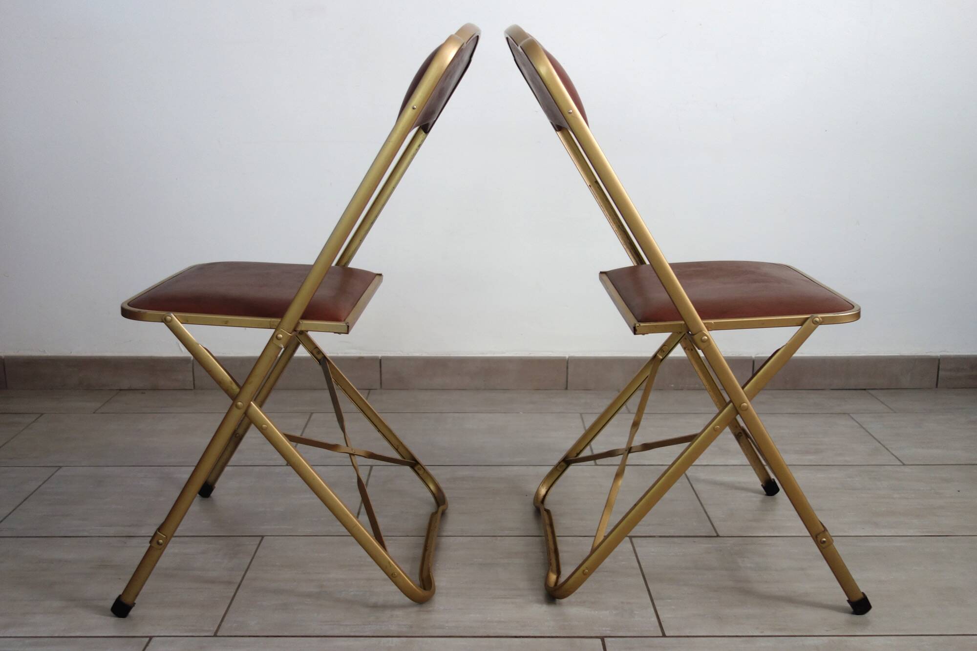 2 golden metal chairs with faux leather in the 60s/70s Opera style.