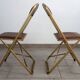 2 golden metal chairs with faux leather in the 60s/70s Opera style.