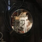 Round mirror surrounded by art deco style metal plants