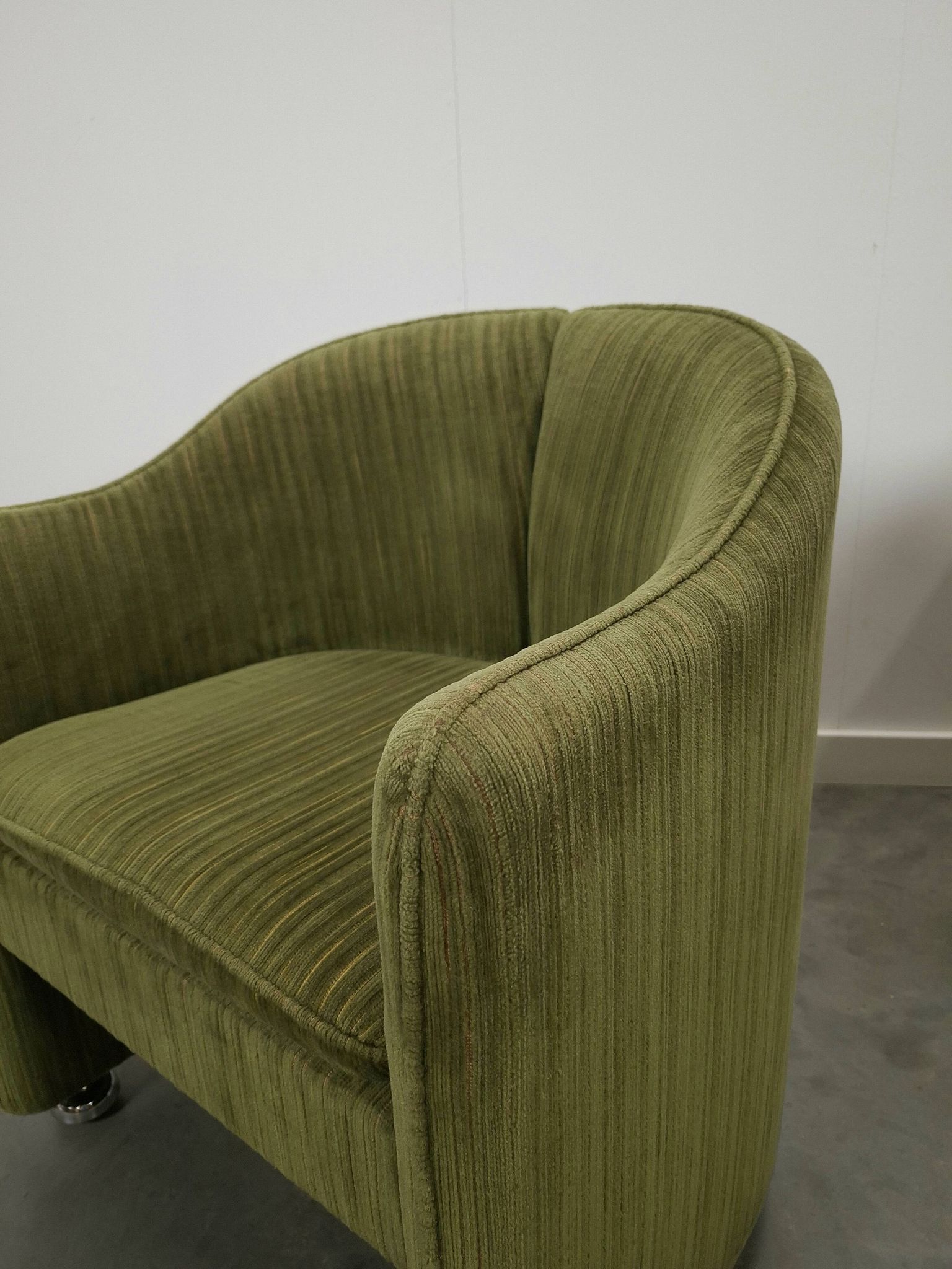 Chaises de cocktail vertes avec des roues chromées.