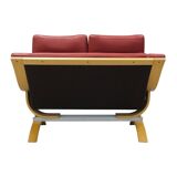Two-seater red leather sofa by Roche Bobois on a bent beech base, France.