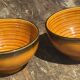 Pair of small orange bowls with black edging