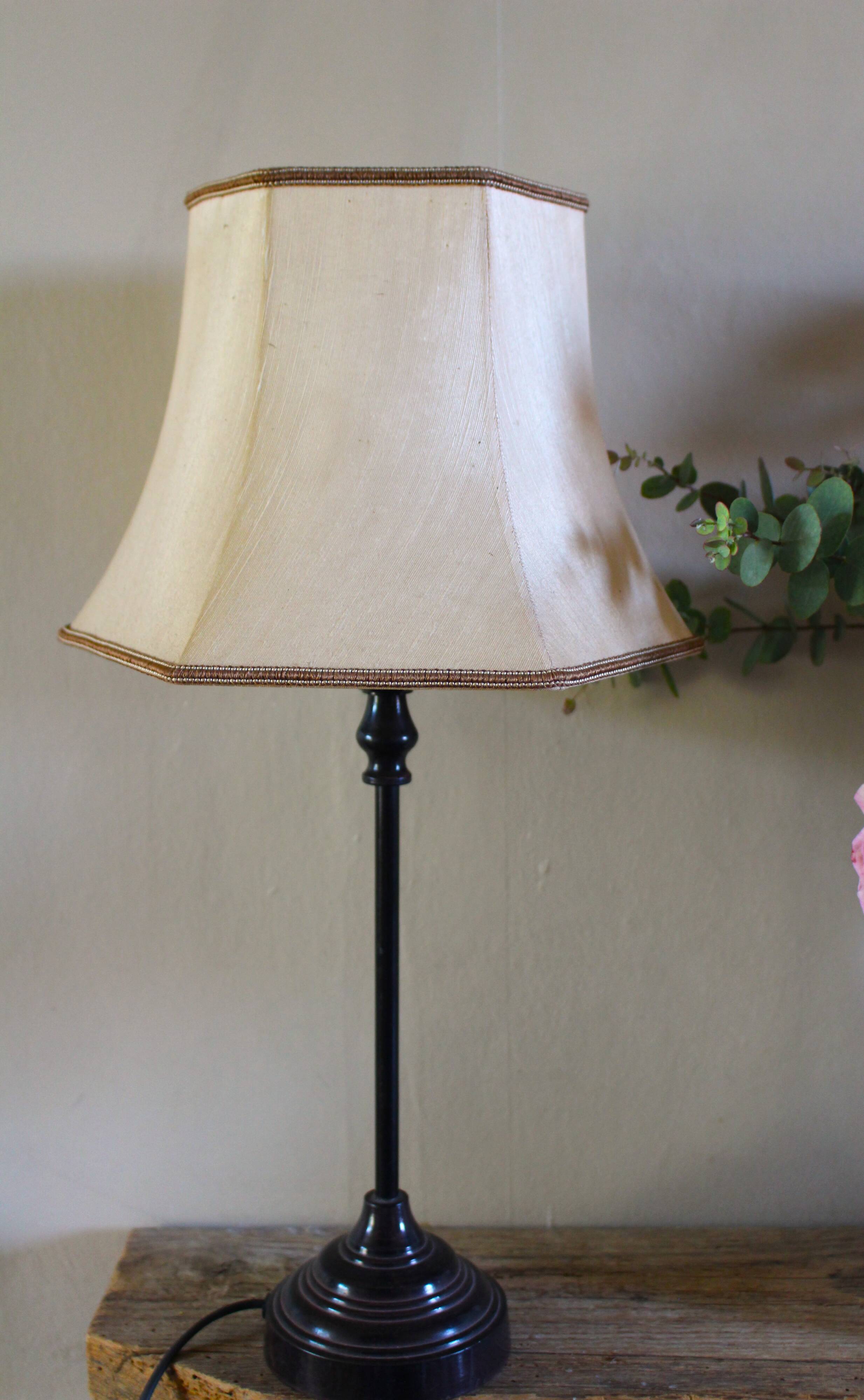 Table lamp with a patinated base and vintage woven shade.